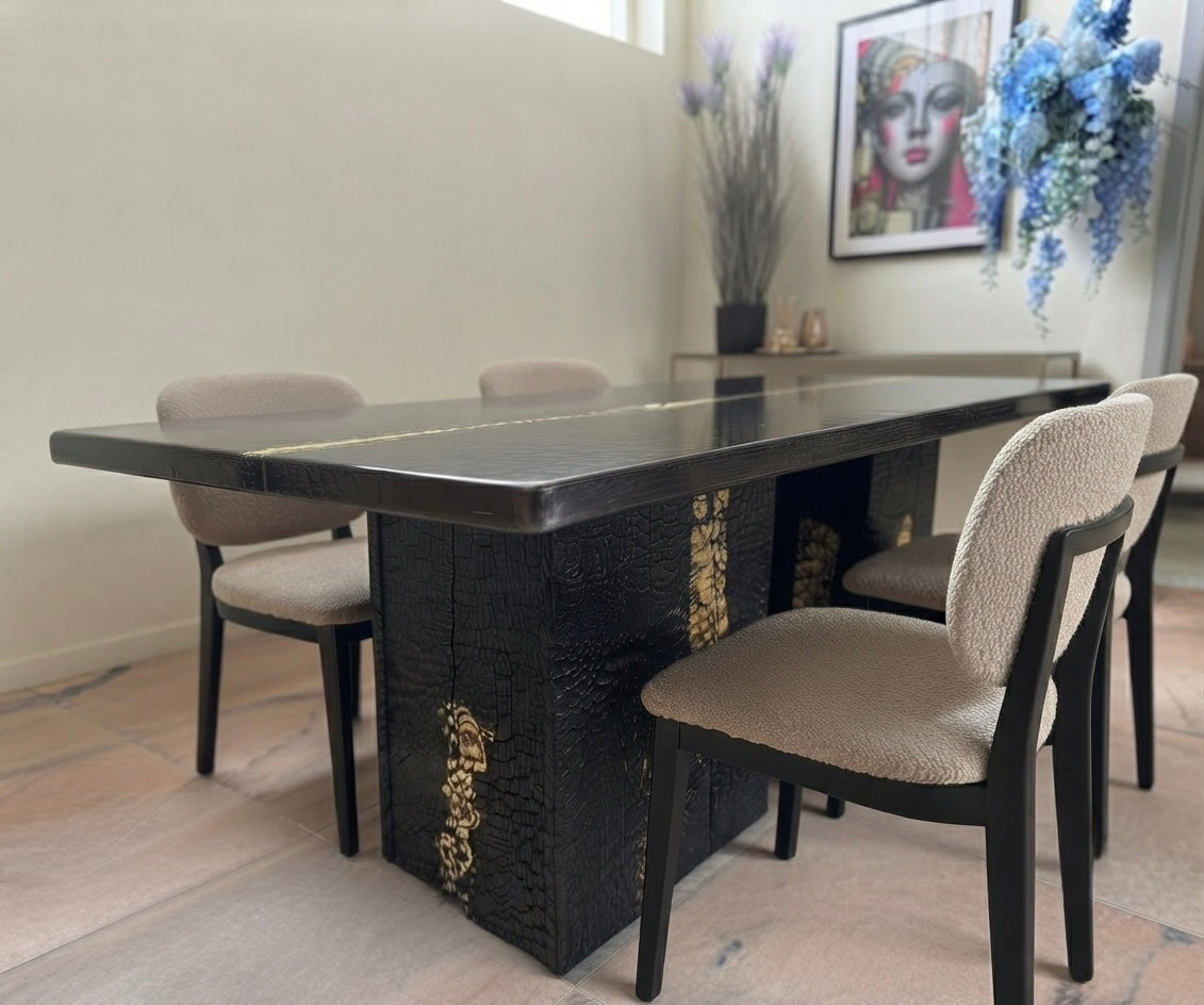 Eettafel van verbrand hout en epoxyhars met goudinleg