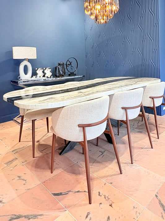 Eettafel met marmerlook blad en beige stoelen in moderne kamer.