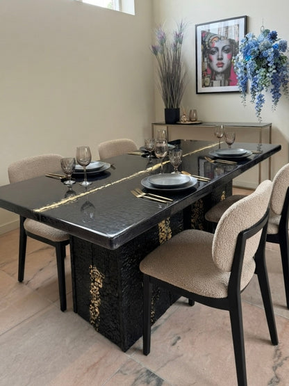 Eettafel van verbrand hout en epoxyhars met goudinleg