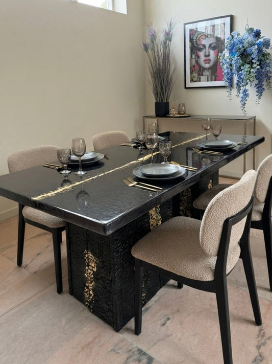 Eettafel van verbrand hout en epoxyhars met goudinleg
