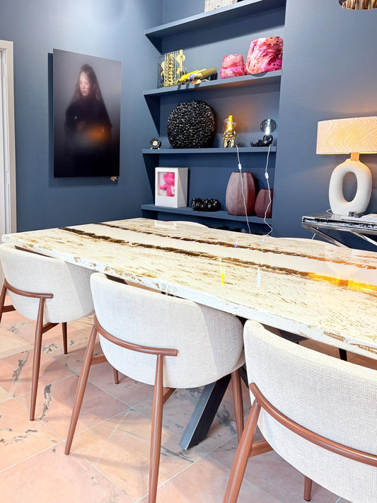 Eettafel met beige stoelen en gouden details in moderne kamer.